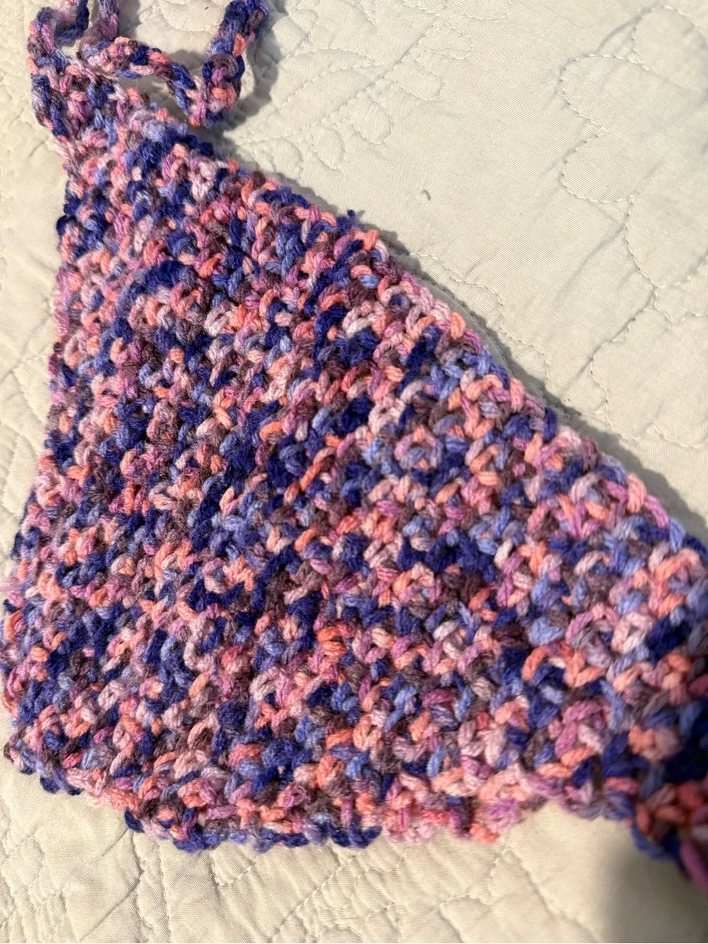 Handmade crochet bandana in pink, blue, and purple marbled yarn.